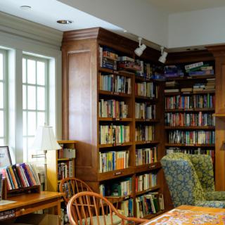 A cozy library corner with wooden bookshelves and comfortable seating.