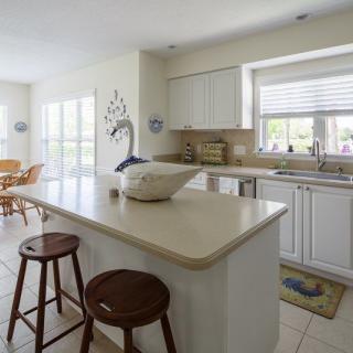 A bright and modern kitchen with an island and stools.