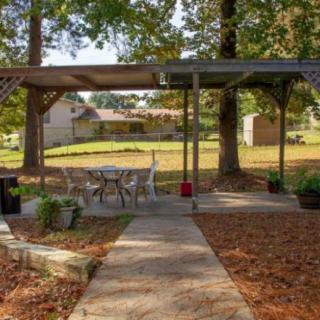 A cozy backyard with a pergola and outdoor seating area surrounded by trees.
