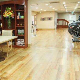 A modern gym interior with wooden flooring and exercise equipment.