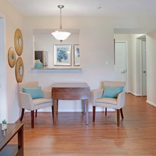 A cozy living area featuring two chairs and a small table, with elegant decor and wooden flooring.