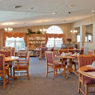 A cozy dining room with neatly arranged tables and chairs, showcasing elegant decor.