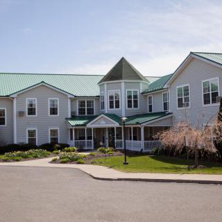 A large residential building with a green roof and well-maintained lawn.