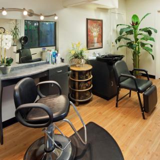 A cozy and well-equipped hair salon interior with stylish seating and decor.
