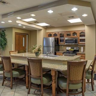 A modern kitchen with a dining area featuring a large table, chairs, and stainless steel appliances.