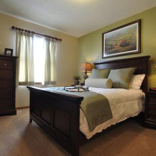A cozy bedroom with elegant furnishings and warm lighting.