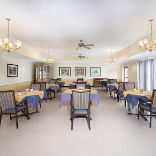 A spacious and well-lit dining room featuring neatly arranged tables and chairs, ideal for gatherings and meals.
