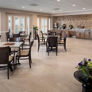 A spacious dining room with neatly arranged tables and a buffet area.