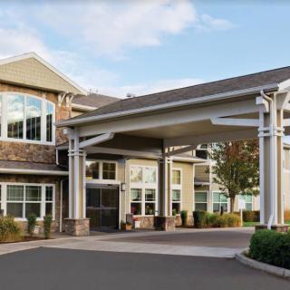 A modern building with a covered entrance and driveway.