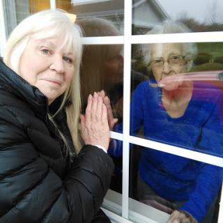 A touching moment of connection through a window, symbolizing love and family ties.
