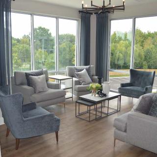 A modern living room with large windows, stylish furniture, and abundant natural light.