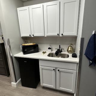 A modern kitchen setup featuring white cabinetry and essential appliances.