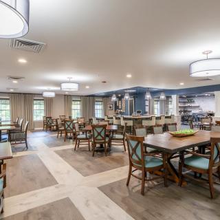 Spacious dining area with multiple tables and chairs, well-lit with modern lighting.