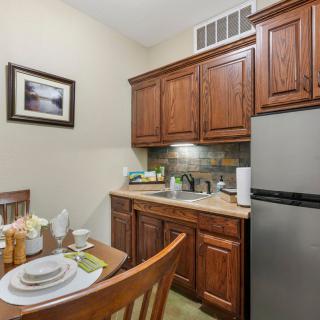 A cozy kitchen with wooden cabinetry and a small dining area.