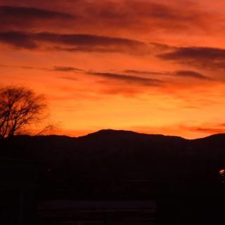 A stunning sunset with vibrant orange hues and silhouetted hills.