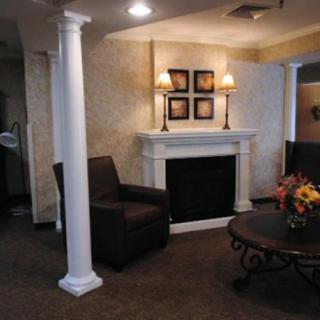 A cozy living room interior featuring a fireplace, armchair, and decorative elements.