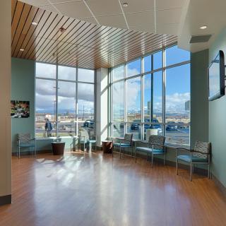 A modern waiting room with large windows and plenty of natural light.
