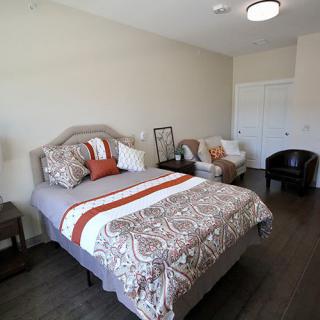 A well-decorated bedroom with a cozy bed, stylish cushions, and comfortable seating.