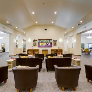 A modern lounge area with comfortable seating and a large television.