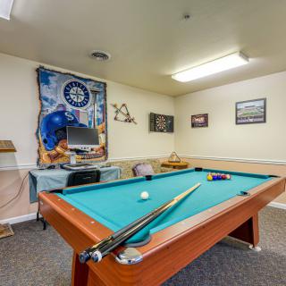 A cozy game room featuring a pool table, sports memorabilia, and recreational decor.