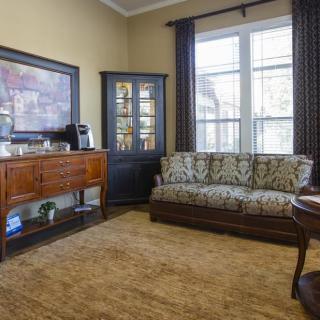 Cozy living room with a sofa, wooden furniture, and a coffee setup.