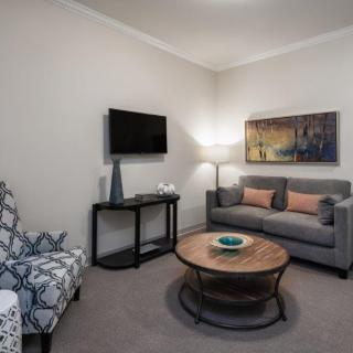 A modern living room with a gray sofa, round coffee table, and wall art.