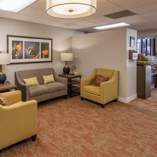 A cozy waiting room with comfortable seating and artwork on the walls.