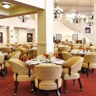 Elegant restaurant interior with neatly arranged tables and chandeliers.