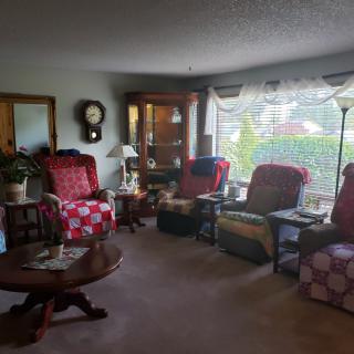 A cozy living room with multiple chairs and a coffee table, decorated with various items.