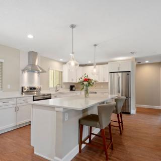 A modern kitchen with an island, stainless steel appliances, and white cabinets.