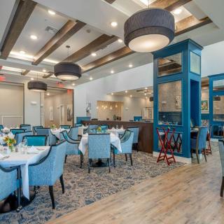 A modern restaurant interior with elegant tables and chairs, featuring stylish lighting and decor.