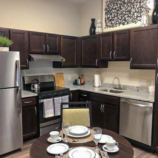 A modern kitchen with dark wood cabinets and a small dining area.