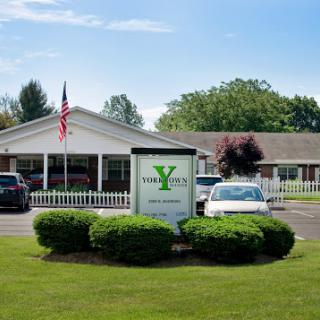 A well-maintained building with a welcoming sign, surrounded by green grass and trees.