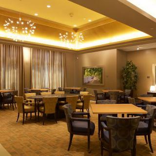 A modern dining area with elegant lighting and neatly arranged tables and chairs.