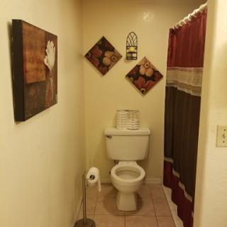 A cozy bathroom featuring a toilet and decorative elements on the walls.