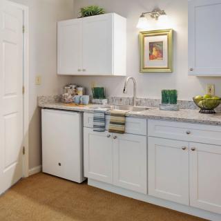 A modern kitchen with white cabinets, a sink, and countertop appliances.