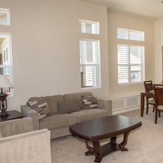 A spacious living room with a sofa, coffee table, and adjoining dining area.