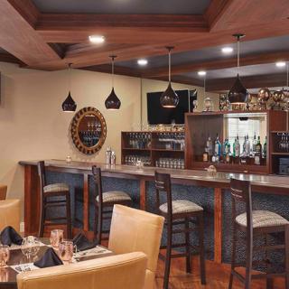 A cozy bar interior with seating and modern lighting.