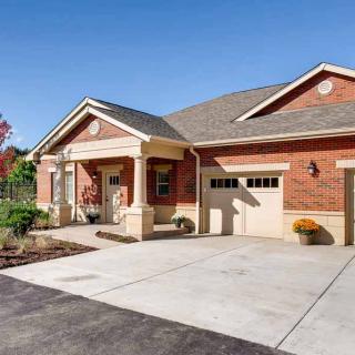 A brick house with a garage and spacious driveway.