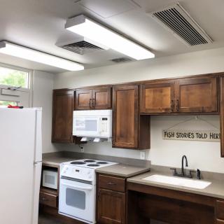 A modern kitchen with wooden cabinets and white appliances.