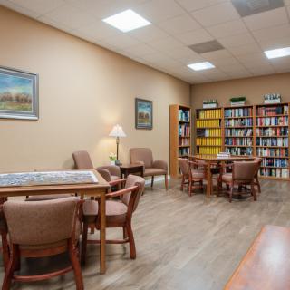 A cozy library reading room with bookshelves and comfortable seating arrangements.
