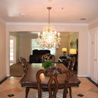 Elegant dining room with a chandelier and classic wooden furniture.