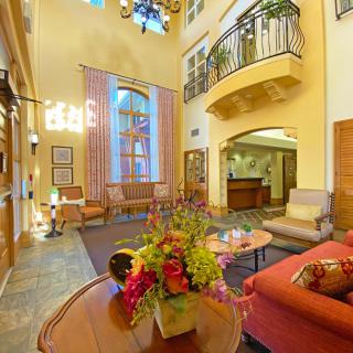 A cozy hotel lobby featuring elegant furniture and vibrant floral arrangements.