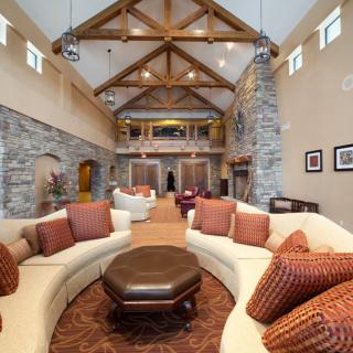 A spacious living room featuring stone walls, exposed wood beams, and elegant furnishings in a luxury home.