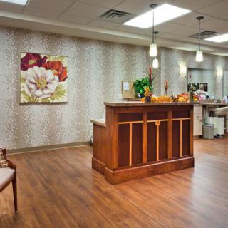 A welcoming reception area with a wooden desk and elegant artwork on the wall.