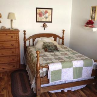 A cozy bedroom with wooden furniture and a patchwork quilt.