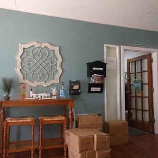 A cozy living room setup featuring a stylish entryway table, decorative wall art, and unpacked boxes.
