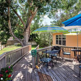 A serene outdoor deck perfect for relaxation, featuring comfortable seating and shaded areas under colorful umbrellas.