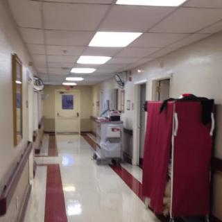 A clean and well-lit hospital hallway with medical equipment.