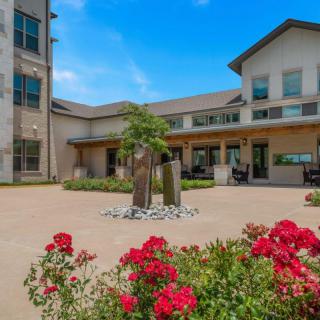 A beautiful courtyard with vibrant flowers and modern architecture.